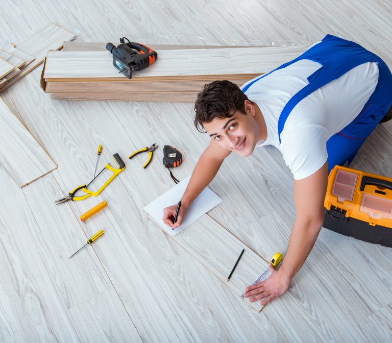 Repairman laying laminate flooring at home flooring-in-portland